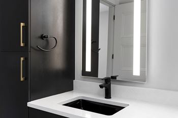 A small bathroom with a sink and a mirror